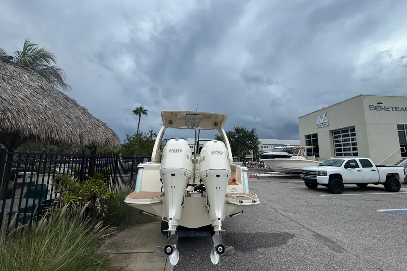 Slide: The Image of 2022 Scout 277 Dorado boat with dual engines in a marina parking lot. - 11