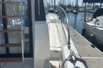 Slide: The Image of 2016 Jeanneau Velasco 37F docked at marina, side view with railing and steps. - 14