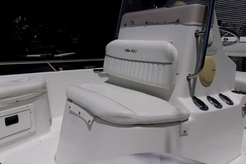 Slide: The Image of 2004 Sea Pro SV1900CC Bay Boat interior with white seating and console details. - 7