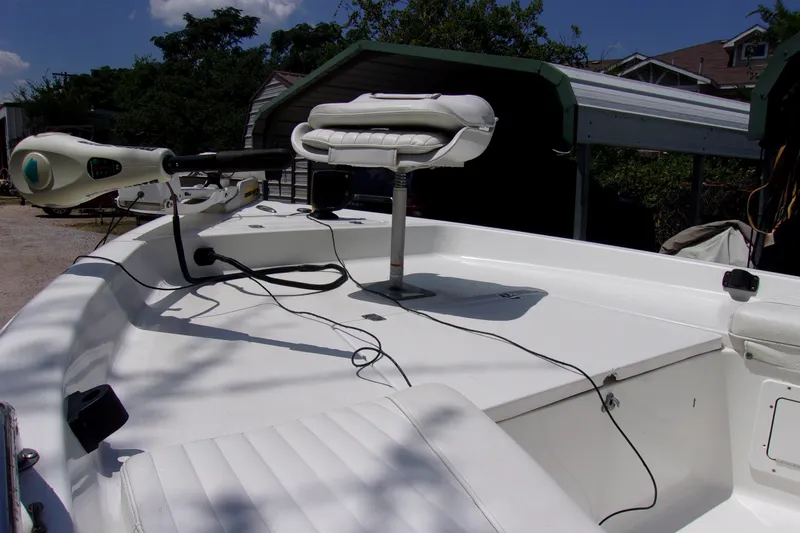 Slide: The Image of 2004 Sea Pro SV1900CC Bay Boat with trolling motor and seating, docked outdoors. - 13