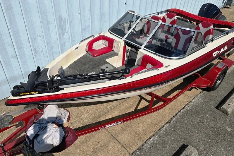 Slide: The Image of 1997 Cajun 1700 Fish and Ski boat with red and white design on a trailer. - 1
