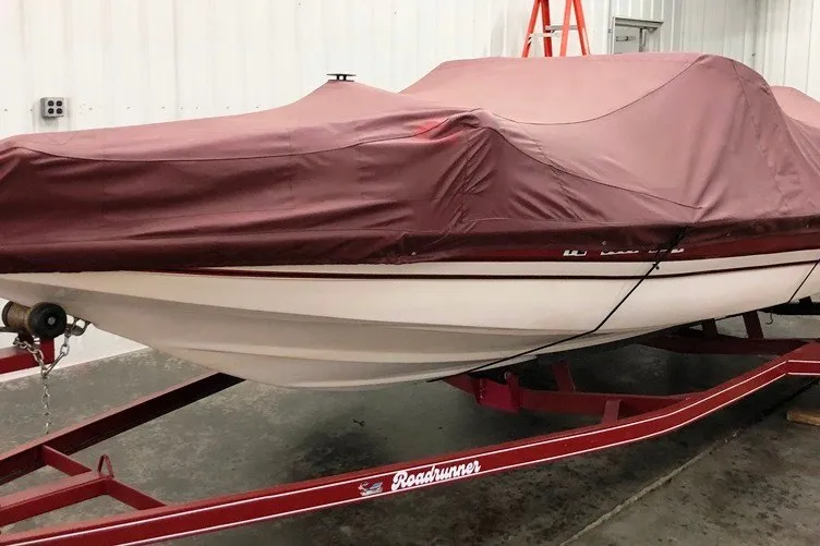 Slide: The Image of 1997 Cajun 1700 Fish and Ski boat covered, on a red Roadrunner trailer. - 15