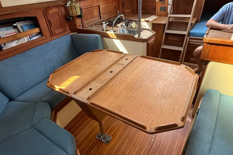 Slide: The Image of Interior of 1994 Pacific Seacraft Crealock 37 sailboat with wooden table and blue seating. - 19