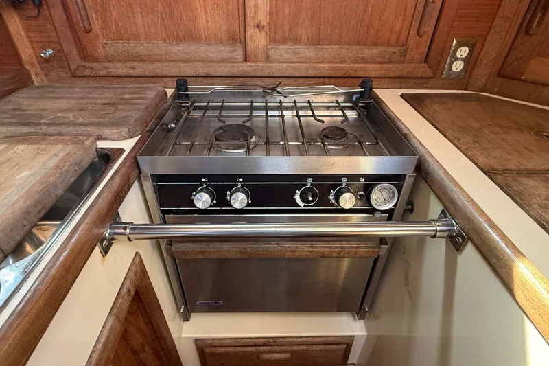 Slide: The Image of Galley kitchen in 1994 Pacific Seacraft 37 sailboat with stove and wooden cabinetry. - 29