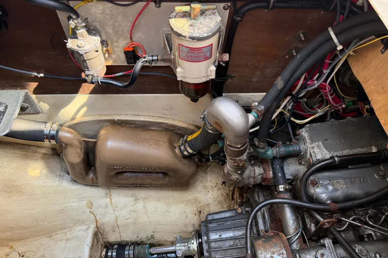 Slide: The Image of Engine compartment of a 1994 Pacific Seacraft Crealock 37 sailboat, showing mechanical components and wiring. - 82