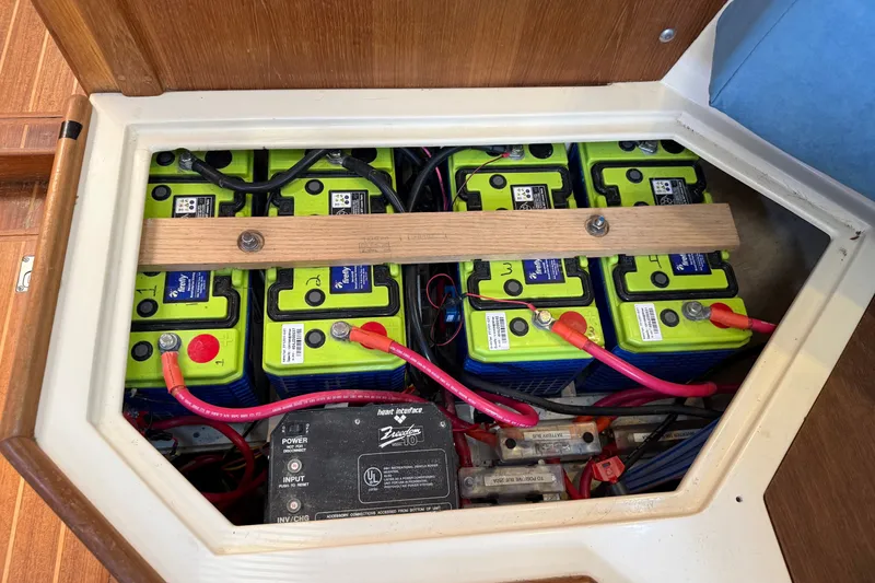 Slide: The Image of Battery compartment of a 1994 Pacific Seacraft Crealock 37 sailboat, featuring multiple green batteries. - 89