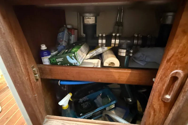 Slide: The Image of Storage cabinet on a 1994 Pacific Seacraft Crealock 37, containing cleaning supplies and plumbing components. - 34