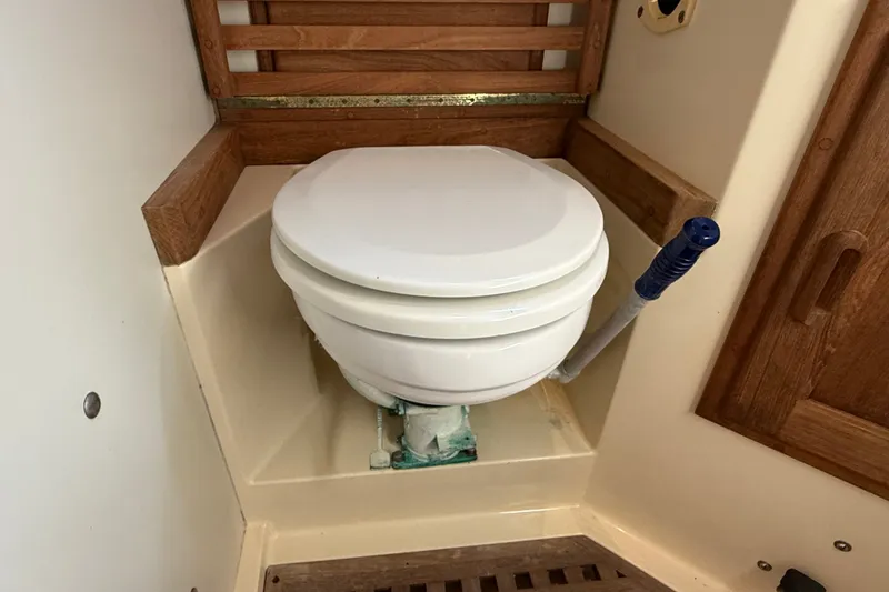 Slide: The Image of 1994 Pacific Seacraft Crealock 37 marine toilet with wooden accents and manual pump handle. - 48