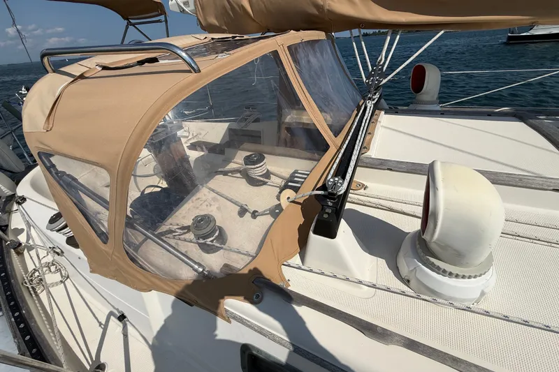 Slide: The Image of 1994 Pacific Seacraft Crealock 37 sailboat cockpit with tan canvas cover and winches. - 65