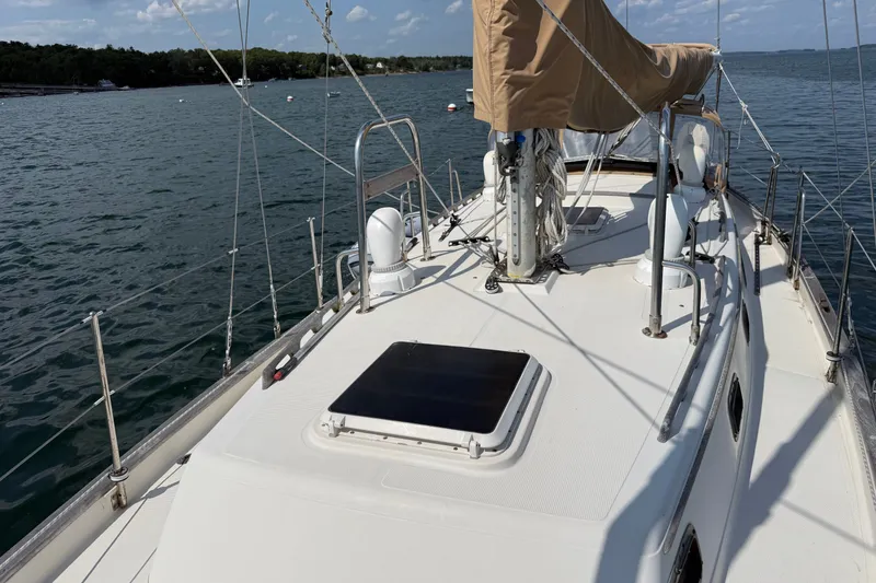 Slide: The Image of 1994 Pacific Seacraft Crealock 37 sailboat deck with mast and rigging on calm water. - 58