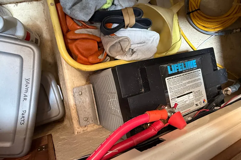 Slide: The Image of Battery and tools in a 1994 Pacific Seacraft Crealock 37 sailboat storage compartment. - 88