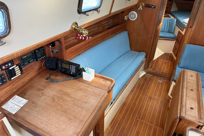 Slide: The Image of Interior of 1994 Pacific Seacraft Crealock 37 sailboat with wooden furnishings and blue cushions. - 12