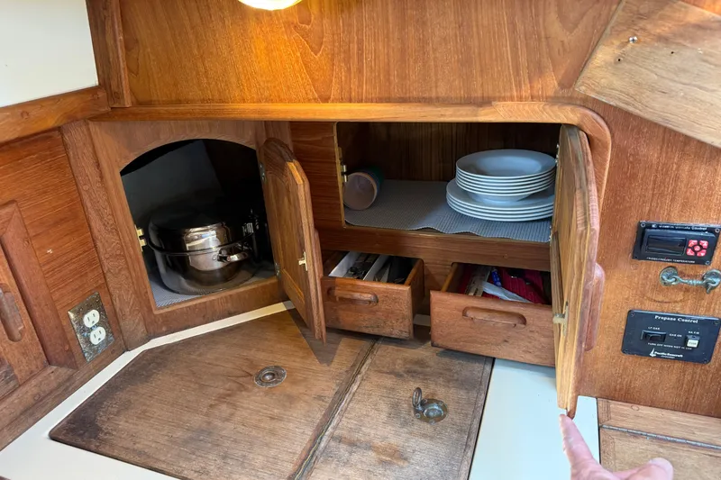 Slide: The Image of Wooden galley storage in 1994 Pacific Seacraft Crealock 37 sailboat, featuring cabinets and drawers. - 36