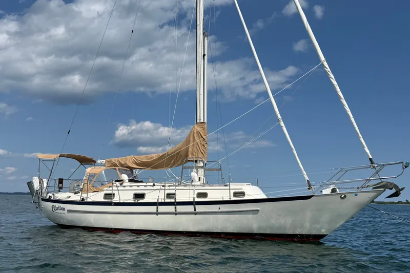 The Image of Sailboat on water, 1994 Pacific Seacraft Crealock 37, under clear blue sky. - 0