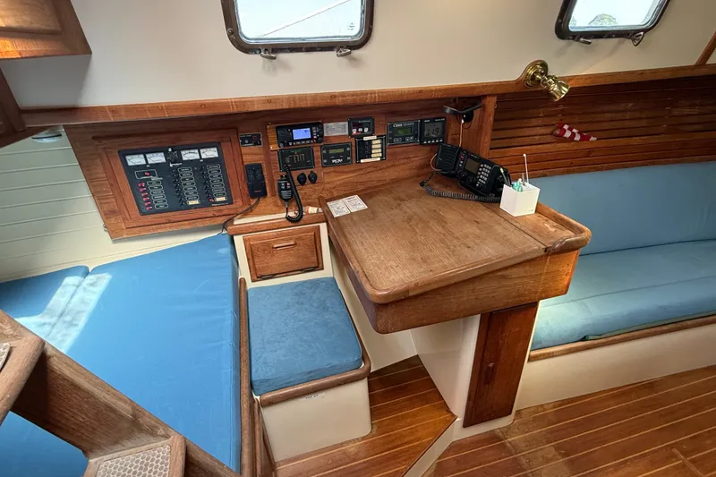 Slide: The Image of Navigation station of a 1994 Pacific Seacraft Crealock 37 sailboat with control panels and seating. - 21