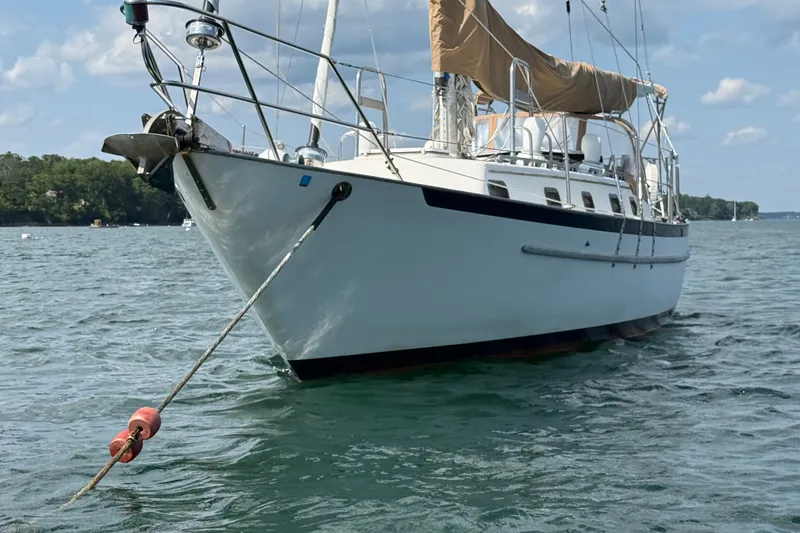 Slide: The Image of 1994 Pacific Seacraft Crealock 37 sailboat anchored on calm water under a clear sky. - 6
