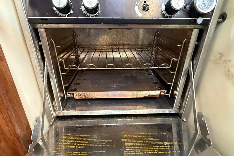 Slide: The Image of Open oven inside a 1994 Pacific Seacraft Crealock 37 sailboat, showing racks and controls. - 31