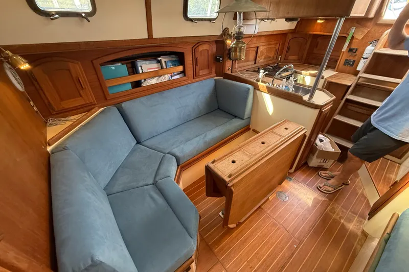 Slide: The Image of Interior of 1994 Pacific Seacraft Crealock 37 sailboat with blue seating and wooden cabinetry. - 18