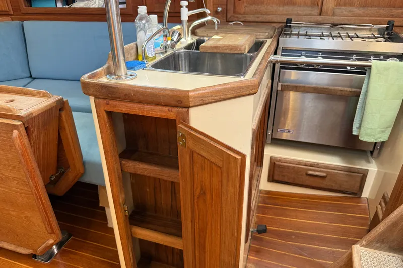 Slide: The Image of Interior of 1994 Pacific Seacraft Crealock 37 sailboat, featuring a compact kitchen area. - 27