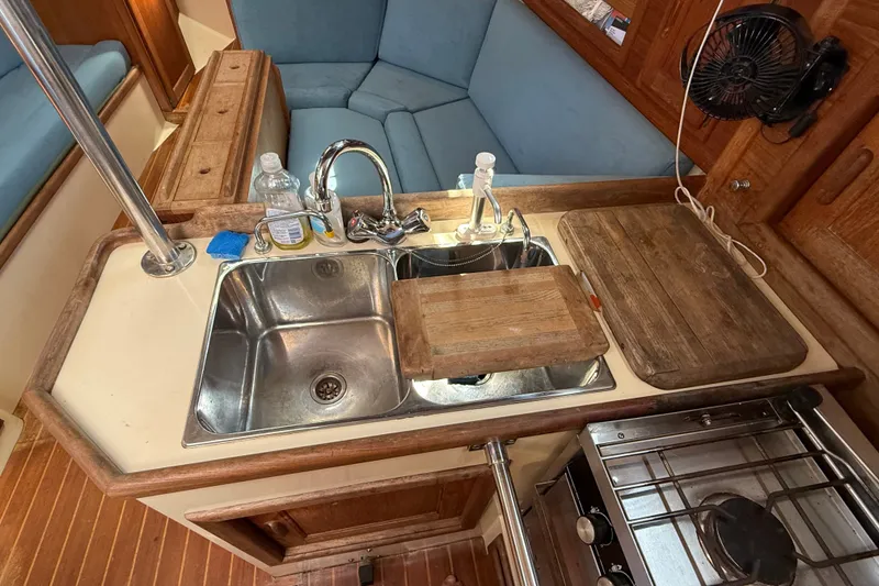 Slide: The Image of 1994 Pacific Seacraft Crealock 37 galley with sink, stove, and wooden countertops. - 26