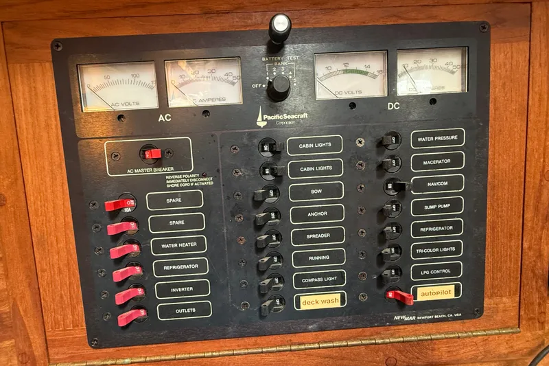 Slide: The Image of Electrical control panel of a 1994 Pacific Seacraft Crealock 37 sailboat, featuring AC and DC switches. - 23
