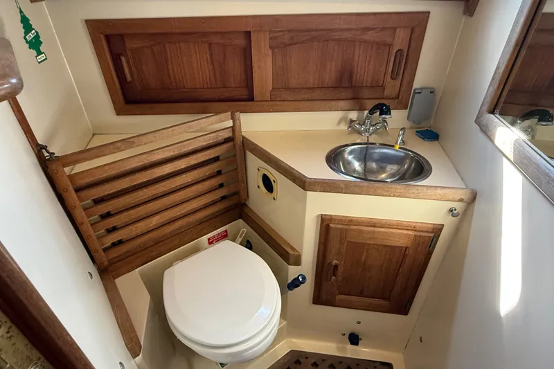 Slide: The Image of 1994 Pacific Seacraft Crealock 37 yacht bathroom with wooden cabinetry and compact sink. - 46