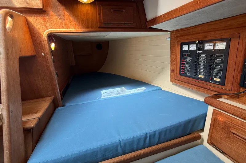 Slide: The Image of Interior cabin of 1994 Pacific Seacraft Crealock 37 sailboat with blue cushions and control panel. - 52