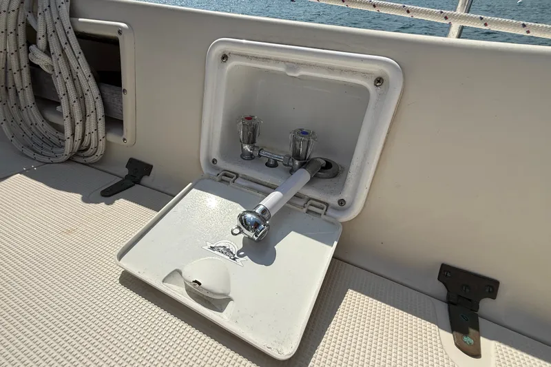 Slide: The Image of Outdoor shower on 1994 Pacific Seacraft Crealock 37 sailboat deck, with coiled rope nearby. - 76