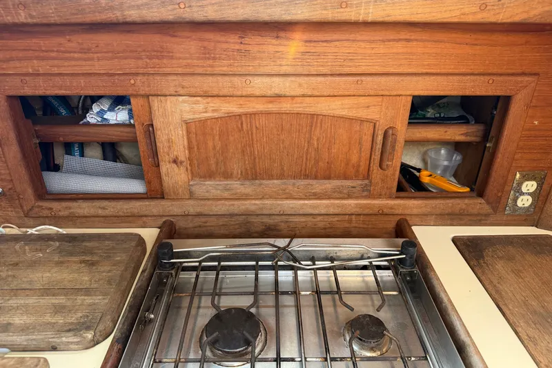 Slide: The Image of Wooden galley interior of 1994 Pacific Seacraft Crealock 37 sailboat with stove and storage. - 28