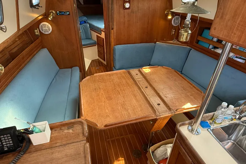 Slide: The Image of Interior of 1994 Pacific Seacraft Crealock 37 sailboat with wooden table and blue seating. - 16