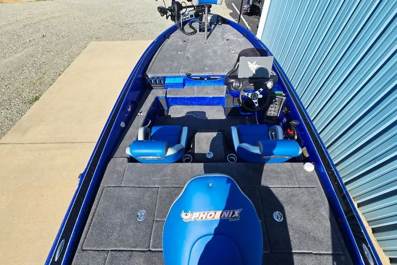 Slide: The Image of 2026 Phoenix 818 Pro boat with blue interior and dual seats, parked near a blue building. - 66
