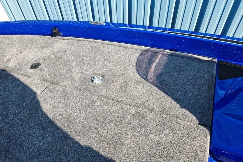 Slide: The Image of Carpeted deck of 2026 Phoenix 818 Pro boat, featuring blue trim and metal fixtures. - 24