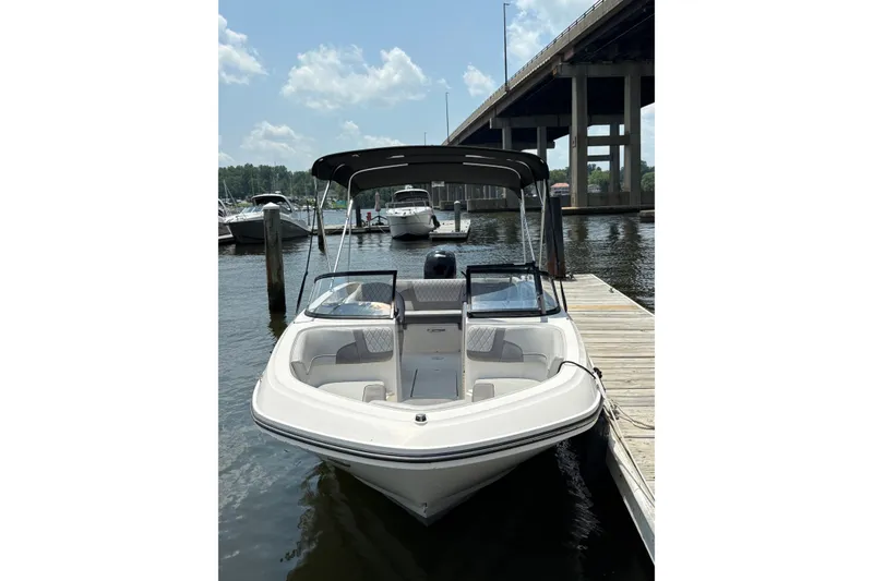 Slide: The Image of 2023 Bayliner VR6 Bowrider OB docked by a marina under a bridge. - 3