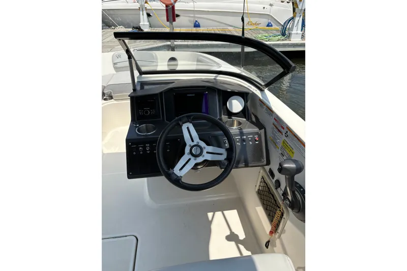 Slide: The Image of 2023 Bayliner VR6 Bowrider OB cockpit with steering wheel and control panel. - 6