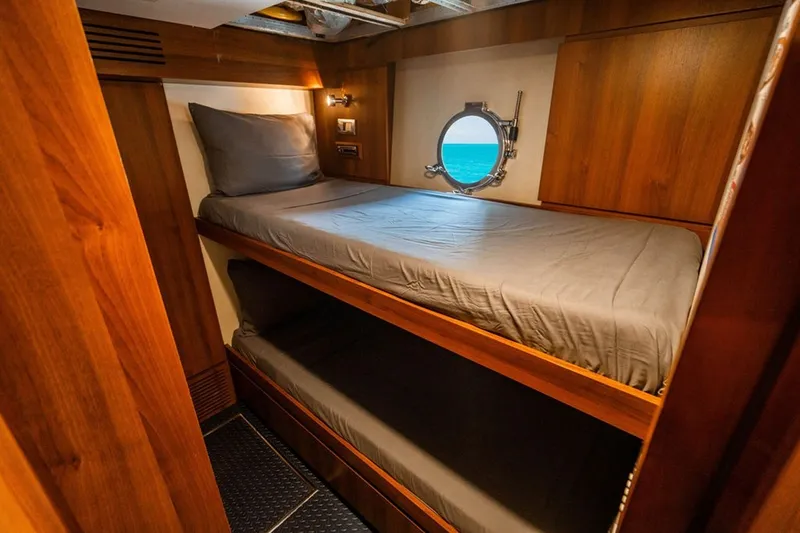 Slide: The Image of Luxurious wooden cabin with bunk beds on 2008 Azimut 95 yacht, featuring ocean view porthole. - 21