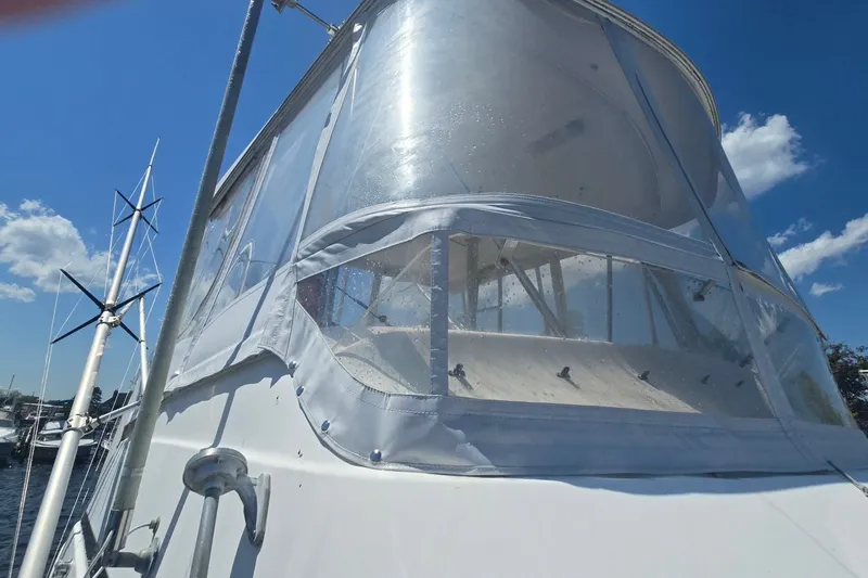 Slide: The Image of 1997 Riviera 34 Convertible boat with clear enclosure under a bright blue sky. - 23