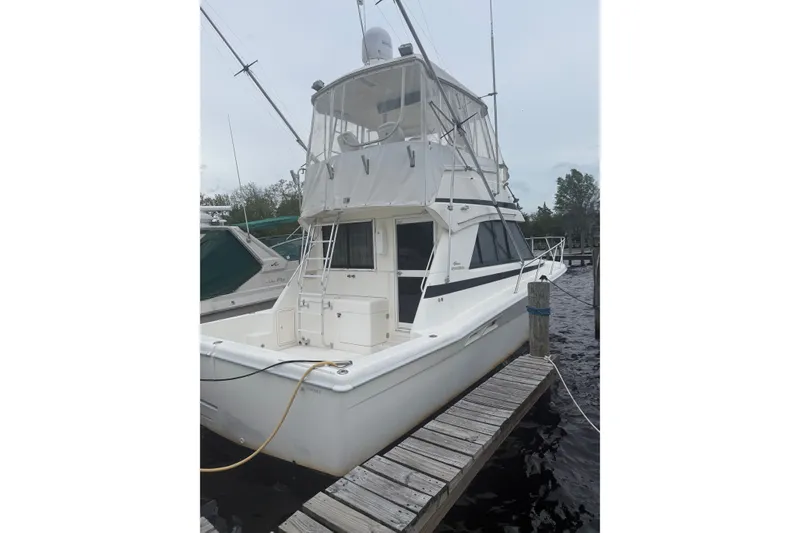 Slide: The Image of 1997 Riviera 34 Convertible yacht docked at marina, side view. - 6