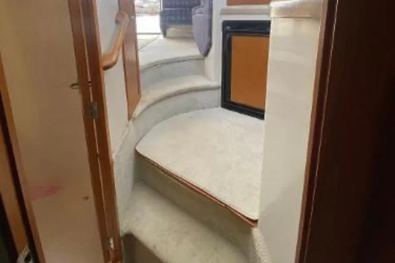 Slide: The Image of Interior view of 1997 Riviera 34 Convertible yacht with carpeted stairs and compact fridge. - 36