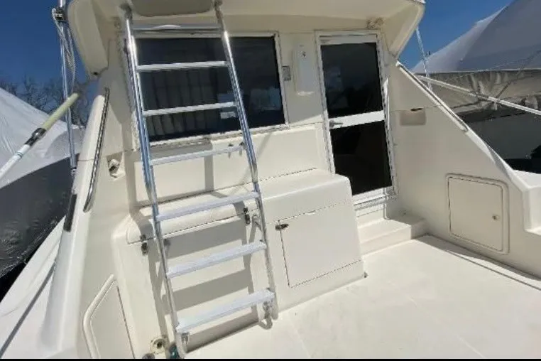 Slide: The Image of 1997 Riviera 34 Convertible yacht deck with ladder and cabin entrance. - 20