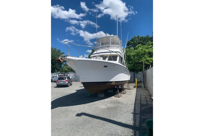 Slide: The Image of 1997 Riviera 34 Convertible boat on dry dock under a clear blue sky. - 14