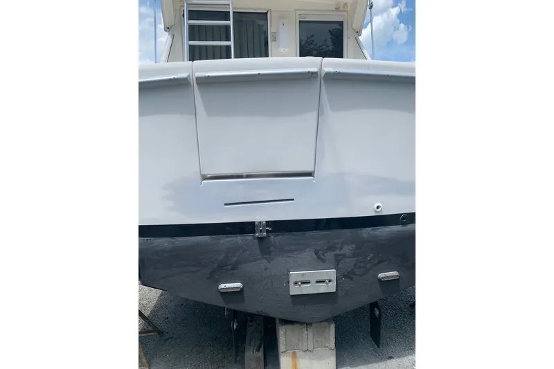 Slide: The Image of 1997 Riviera 34 Convertible boat stern view with ladder and clear sky. - 10