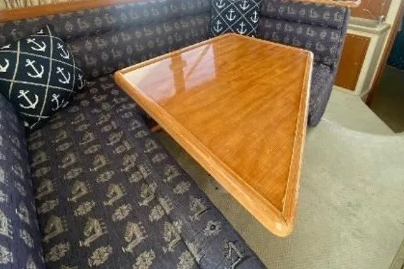 Slide: The Image of Interior of 1997 Riviera 34 Convertible with triangular wooden table and nautical-themed seating. - 39