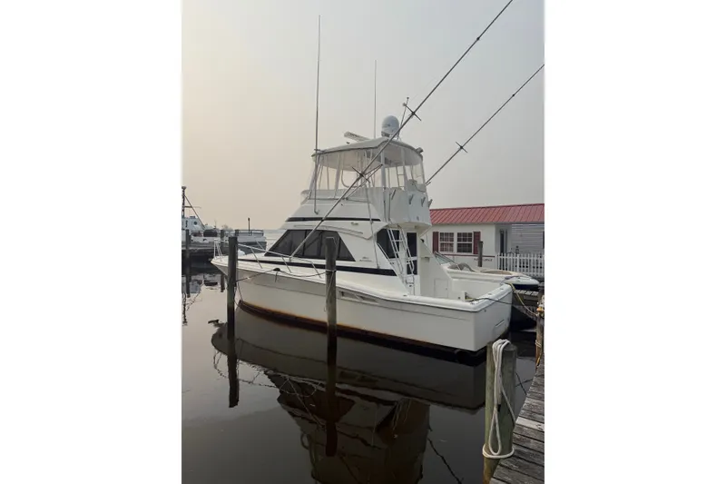 Slide: The Image of 1997 Riviera 34 Convertible yacht docked at marina, featuring fishing rods and flybridge. - 5