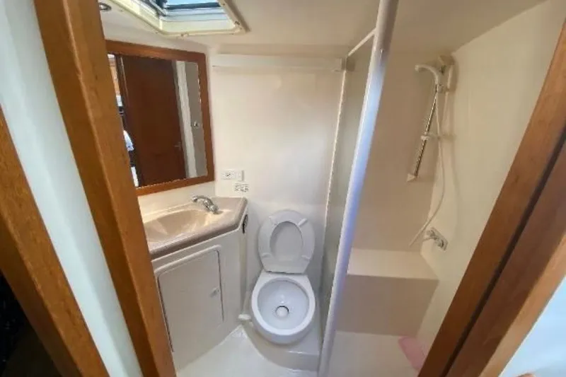 Slide: The Image of Bathroom interior of 1997 Riviera 34 Convertible yacht, featuring toilet, sink, and shower. - 35