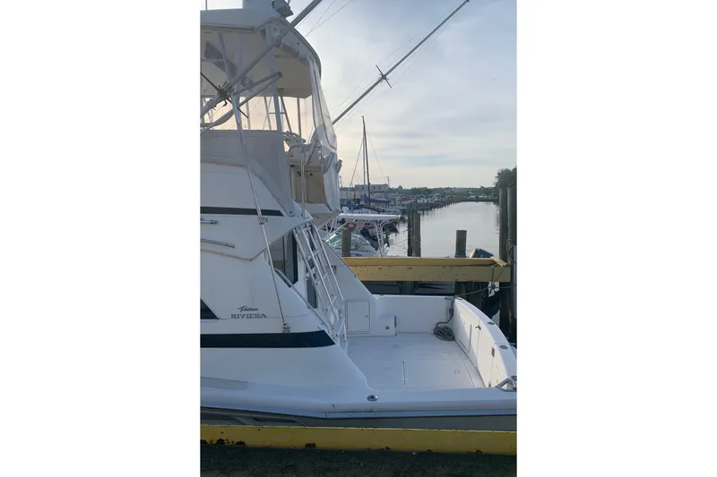 Slide: The Image of 1997 Riviera 34 Convertible yacht docked at a marina, showcasing its spacious deck. - 28