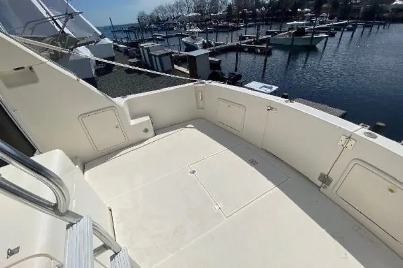 Slide: The Image of 1997 Riviera 34 Convertible yacht deck overlooking marina with boats and calm water. - 21
