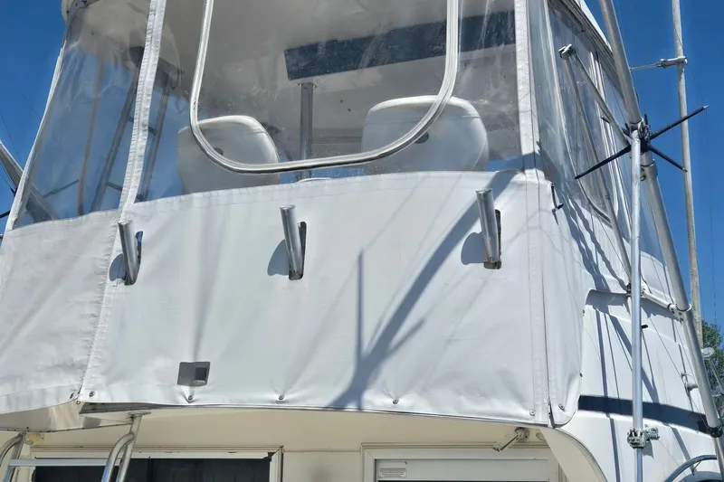 Slide: The Image of 1997 Riviera 34 Convertible boat with white canvas enclosure and metal supports. - 26