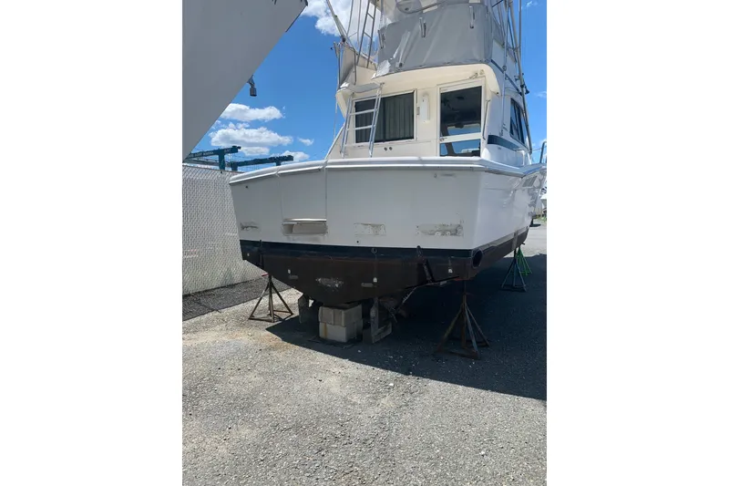 Slide: The Image of 1997 Riviera 34 Convertible boat on stands, viewed from the rear in a boatyard. - 15