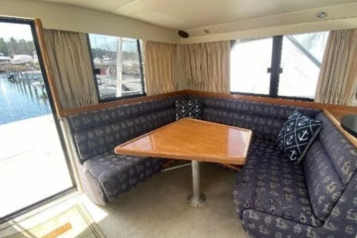 Slide: The Image of Interior of 1997 Riviera 34 Convertible yacht with cozy dining area and nautical-themed cushions. - 41