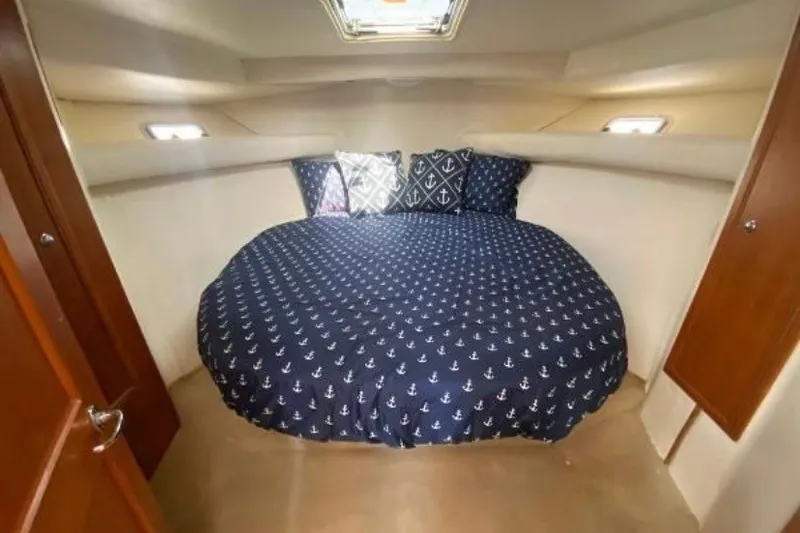 Slide: The Image of Cozy cabin interior of 1997 Riviera 34 Convertible with nautical-themed bedding. - 42